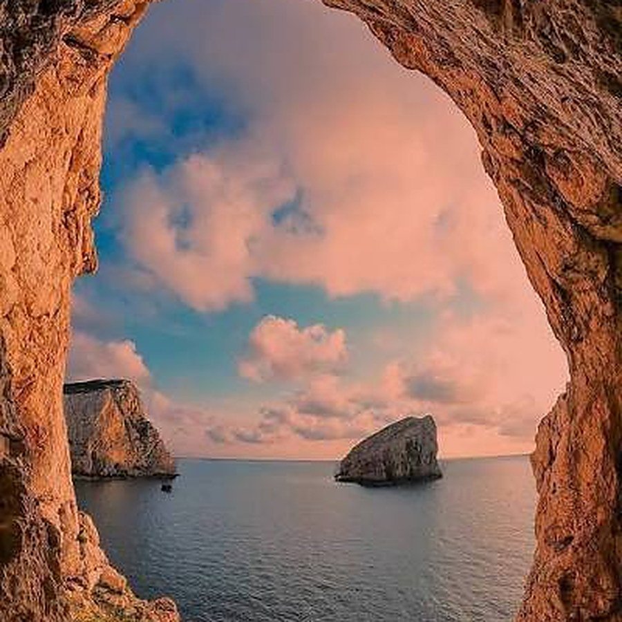 El arco de roca de Capo Caccia, cerca de Alghero, al atardecer, con la isla Foradada en el mar.